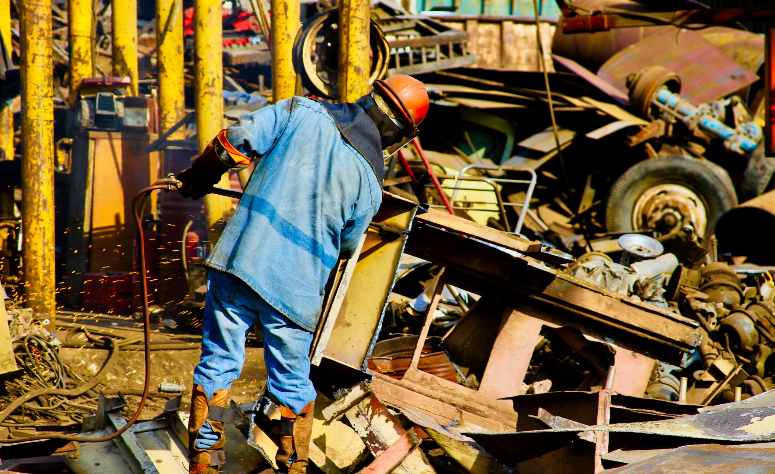 Worker managing scrap metal pile at INCA Metal yard